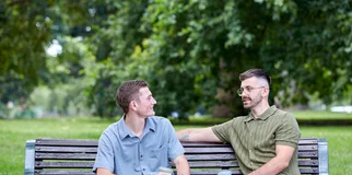 two boys sitting on park bench