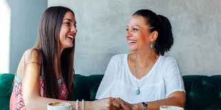 Mother and daughter laughing in coffee shop width 960