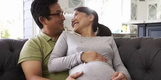 Pregnant wife smiles at husband width 960