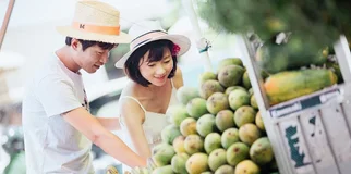 Young Chinese couple selecting fruit at market