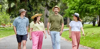 two men and two women walking in a park