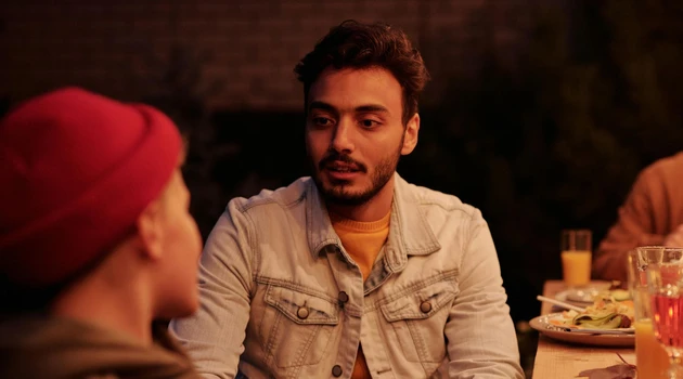 Young man in conversation at dinner party 3