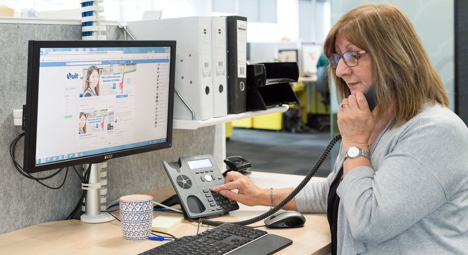 Woman talking on the phone at her desk