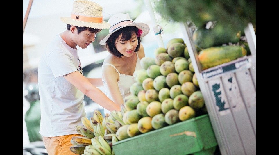 Young Chinese couple selecting fruit at market