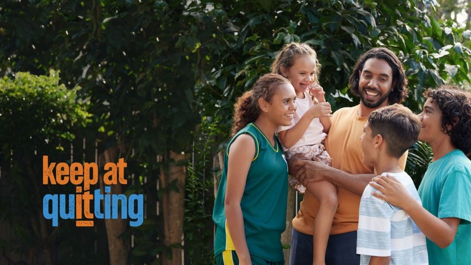 Aboriginal family smiling at each other outside